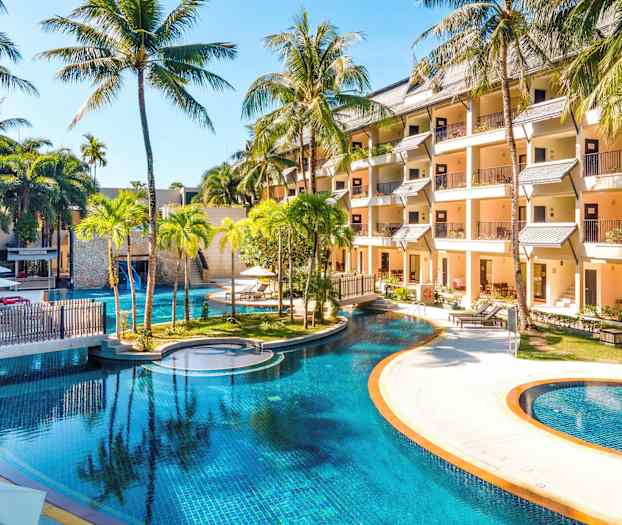 Hotellialue, jossa suuri uima-allas, ympärillä palmuja ja rakennuksia. (Tekoälyn luoma teksti)