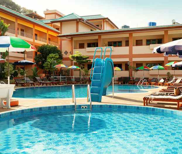 Hotellin uima-allasalue aurinkotuoleineen ja varjoineen. (Tekoälyn luoma teksti)