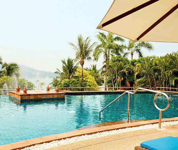 Ulkouima-allas, josta on näkymä vihreille palmuille ja metsän peittämille kukkuloille. Etualalla aurinkotuoleja ja varjo. (Tekoälyn luoma teksti)