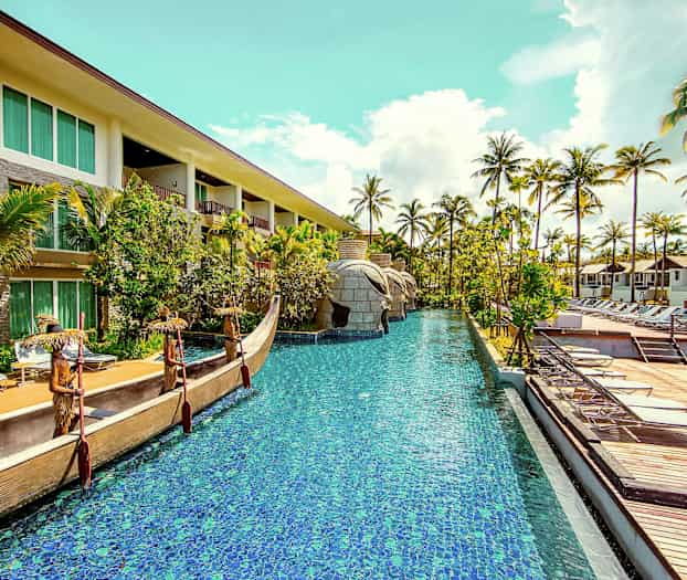 Hotellialue, jossa uima-allas, ympäröity palmuilla ja aurinkotuoleilla. (Tekoälyn luoma teksti)