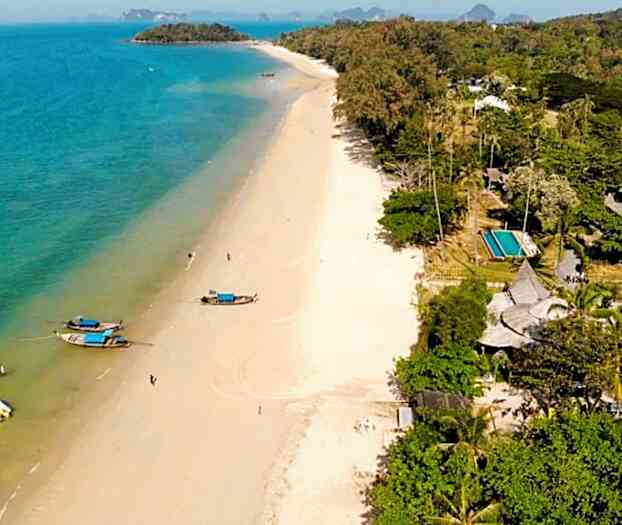 Ranta, jossa veneitä veden äärellä ja vihreitä puita lähellä. (Tekoälyn luoma teksti)