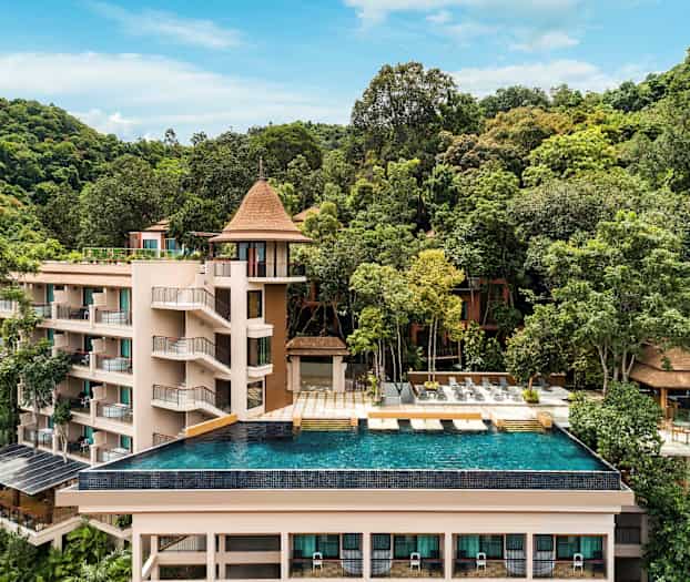 Lomakeskus, jota ympäröi vehreys, ja etualalla on infinity-allas. (Tekoälyn luoma teksti)