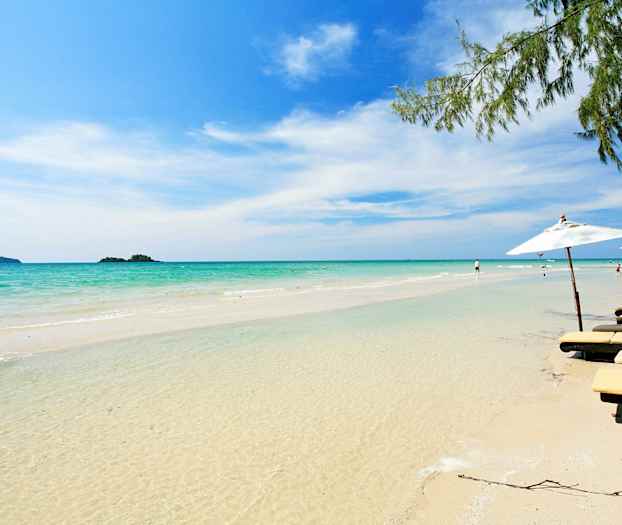 Hiekkaranta, kirkasta vettä, aurinkotuoleja ja aurinkovarjoja reunoilla. (Tekoälyn luoma teksti)