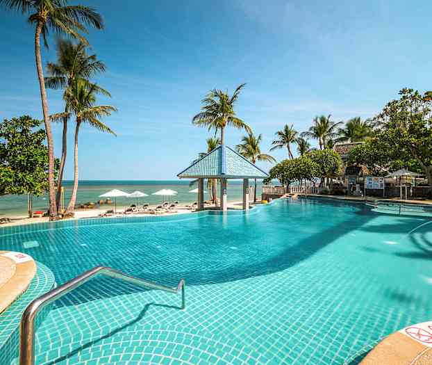 Ulkouima-allas hiekkarannan vieressä, ympärillä palmuja ja aurinkotuoleja. (Tekoälyn luoma teksti)