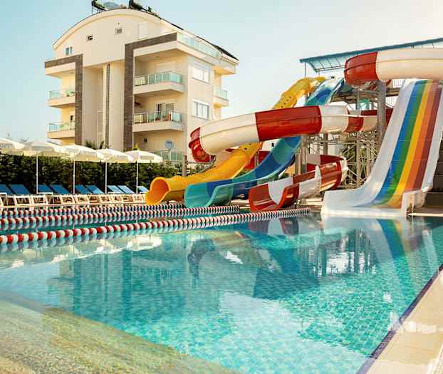 Ulkouima-allas, vesiliukumäet ja aurinkotuoleja asuinrakennuksen lähellä. (Tekoälyn luoma teksti)