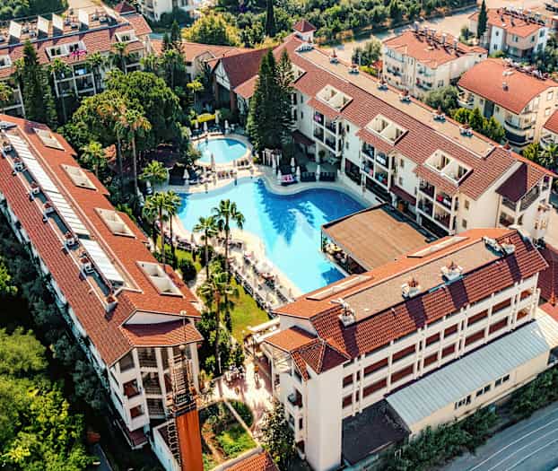 Ilmakuva hotellialueesta, jossa on uima-allas ja ympäröiviä rakennuksia. (Tekoälyn luoma teksti)
