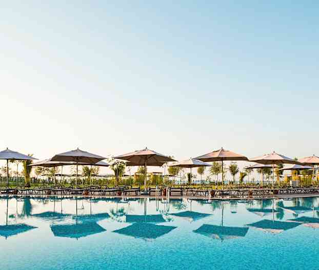 Uima-allas, jonka reunalla on aurinkotuoleja ja varjoja. (Tekoälyn luoma teksti)