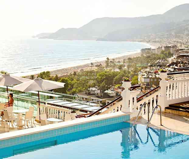 Kuva uima-altaasta, josta on näkymä rannalle ja kaupunkiin. (Tekoälyn luoma teksti)