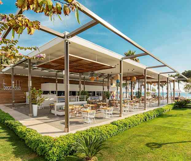 Moderni ulkoravintola ulkoterassilla, jota ympäröi vehreä alue. (Tekoälyn luoma teksti)