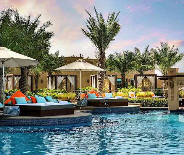 Uima-allas, jota ympäröivät aurinkotuolit, aurinkovarjot ja palmut lomakeskuksessa. (Tekoälyn luoma teksti)