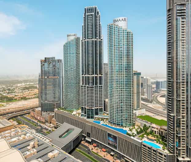 Kaupunkikuva, jossa useita korkeita pilvenpiirtäjiä ja valtatie etualalla. (Tekoälyn luoma teksti)