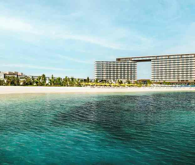 Näkymä hotellille hiekkarannan ja kirkkaan veden läheisyydessä. (Tekoälyn luoma teksti)