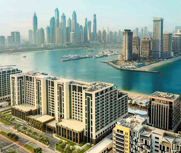 Kaupunkinäkymä moderneista rakennuksista ja satamasta veden äärellä. (Tekoälyn luoma teksti)