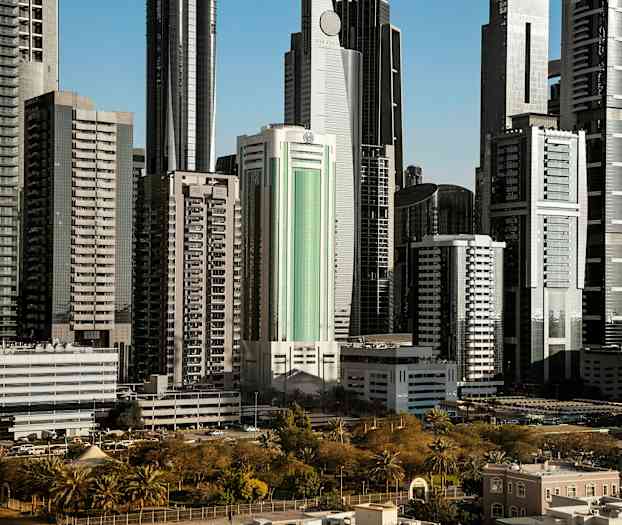 Korkeat modernit rakennukset, joita ympäröivät viheralueet ja puistot. (Tekoälyn luoma teksti)