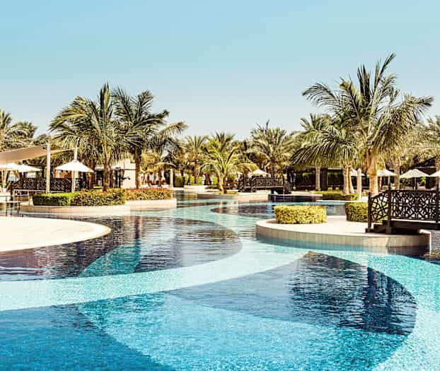 Lomakeskusallas palmuineen ja istuma-alue taustalla. (Tekoälyn luoma teksti)