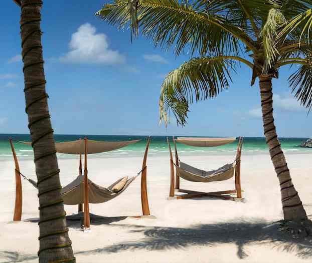 Aurinkoiset rannat riippumattoineen ja palmupuineen meren äärellä. (Tekoälyn luoma teksti)