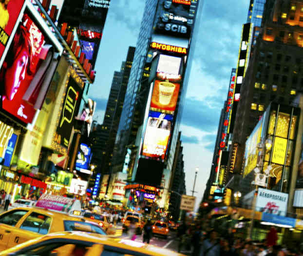 Liikennöity katu, jossa takseja ja mainoksilla peitettyjä rakennuksia kaupunkialueella. (Tekoälyn luoma teksti)