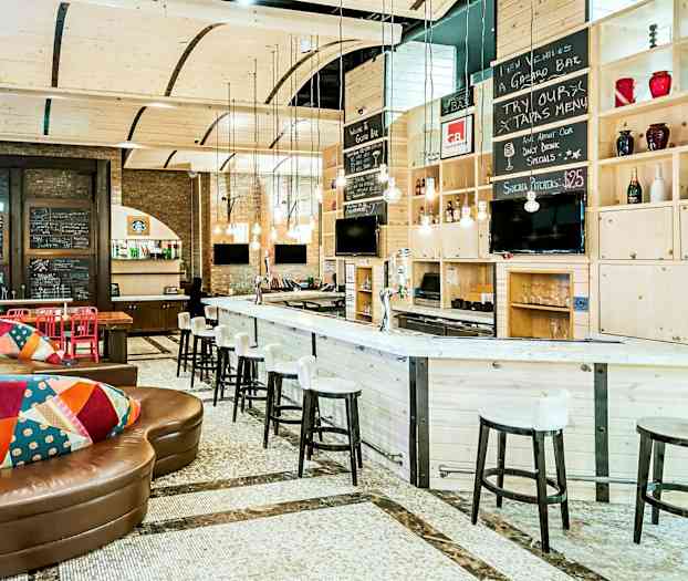 Moderni baari, jossa on puinen sisustus, istuimia ja koristeellisia yksityiskohtia. (Tekoälyn luoma teksti)