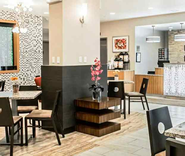 Hotellin aula, jossa on istuimia, koristeita ja vastaanottoalue. (Tekoälyn luoma teksti)