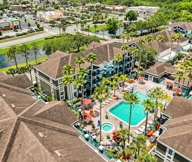 Kuva lomakeskuksesta, jossa on uima-allas ja ympäröivät rakennukset, kuvattu ylhäältä. (Tekoälyn luoma teksti)