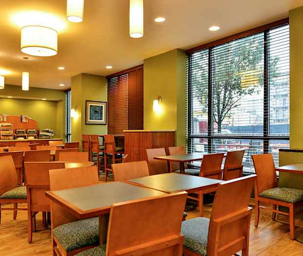 Ravintola, jossa on pöytiä, tuoleja ja tarjoilutiski. (Tekoälyn luoma teksti)