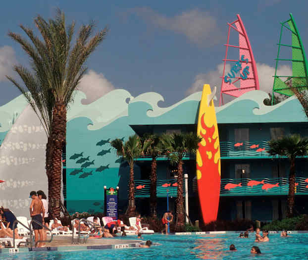 Uima-allas, jota ympäröivät aurinkotuolit ja ihmiset. Taustalla on rakennus, jossa on värikäs koristelu aaltojen, kalojen ja suuren surffilaudan muodossa. (Tekoälyn luoma teksti)