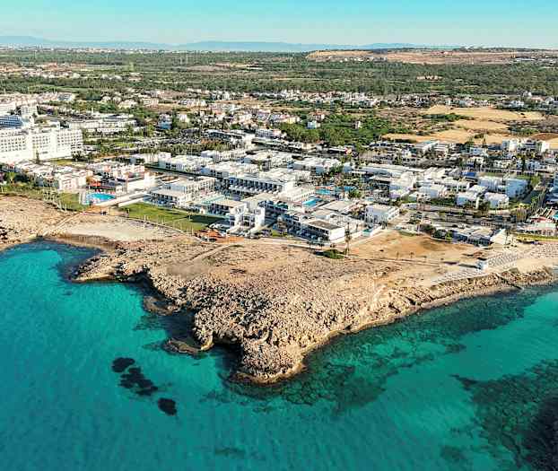 Ilmakuva rannikkokaupungista hotelleineen ja sinisine merineen. (Tekoälyn luoma teksti)