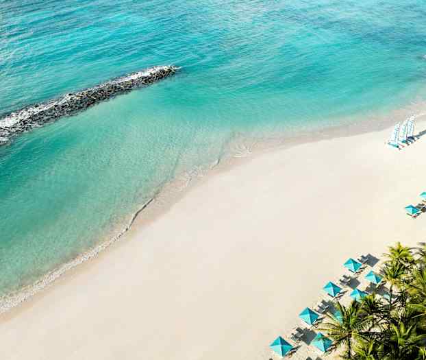 Hiekkaranta, turkoosi meri ja aurinkovarjoja. (Tekoälyn luoma teksti)