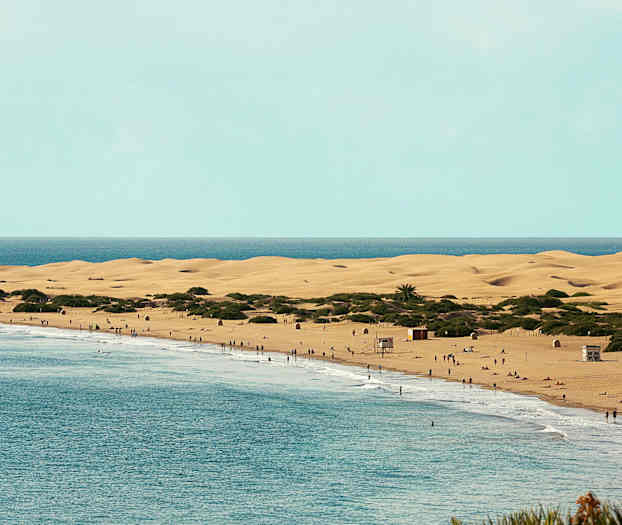 Ranta hiekkadyyneillä ja ihmisiä veden äärellä. (Tekoälyn luoma teksti)