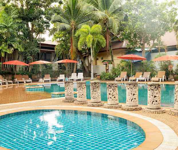 Ulkoilma-allas, jota ympäröivät palmupuut ja aurinkotuolit varjolla. (Tekoälyn luoma teksti)