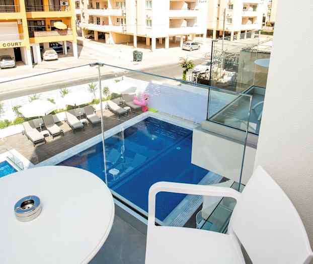 Parveke, jolta on näkymä uima-altaaseen ja naapurirakennuksiin. (Tekoälyn luoma teksti)