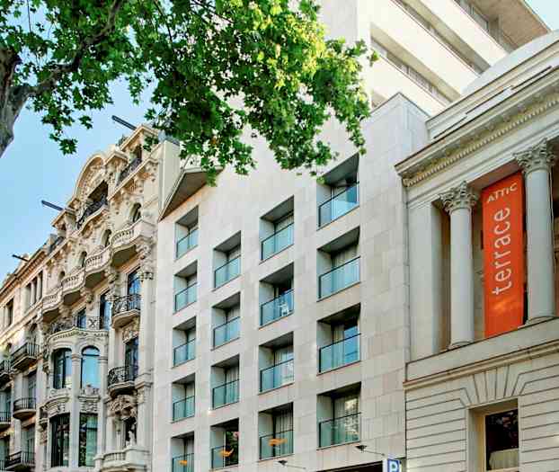 Katu, jolla on useita rakennuksia, mukaan lukien hotelli, jossa on kyltti "Citadines", ja muita arkkitehtonisia tyylejä. (Tekoälyn luoma teksti)