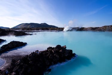 Islantilainen höyryävä turkoosinsininen laguuni, jota ympäröi vulkaaninen musta kiviaines.
