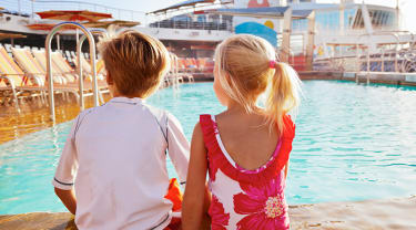 Kaksi lasta istuu risteilyaluksen uima-altaan reunalla