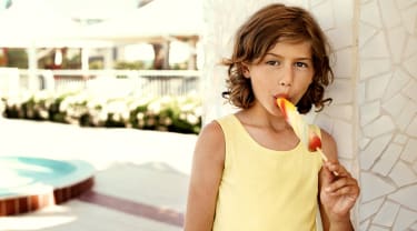 Lapsi syö jäätelöä hotellin allasalueella
