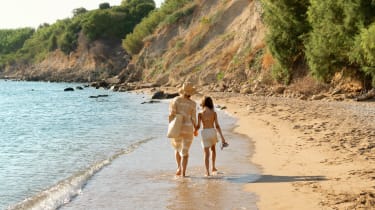 Nainen ja tyttö kävelemässä rannalla