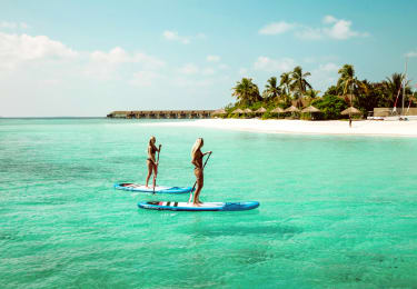 Kaksi ihmistä SUP-lautailemassa Malediiveilla