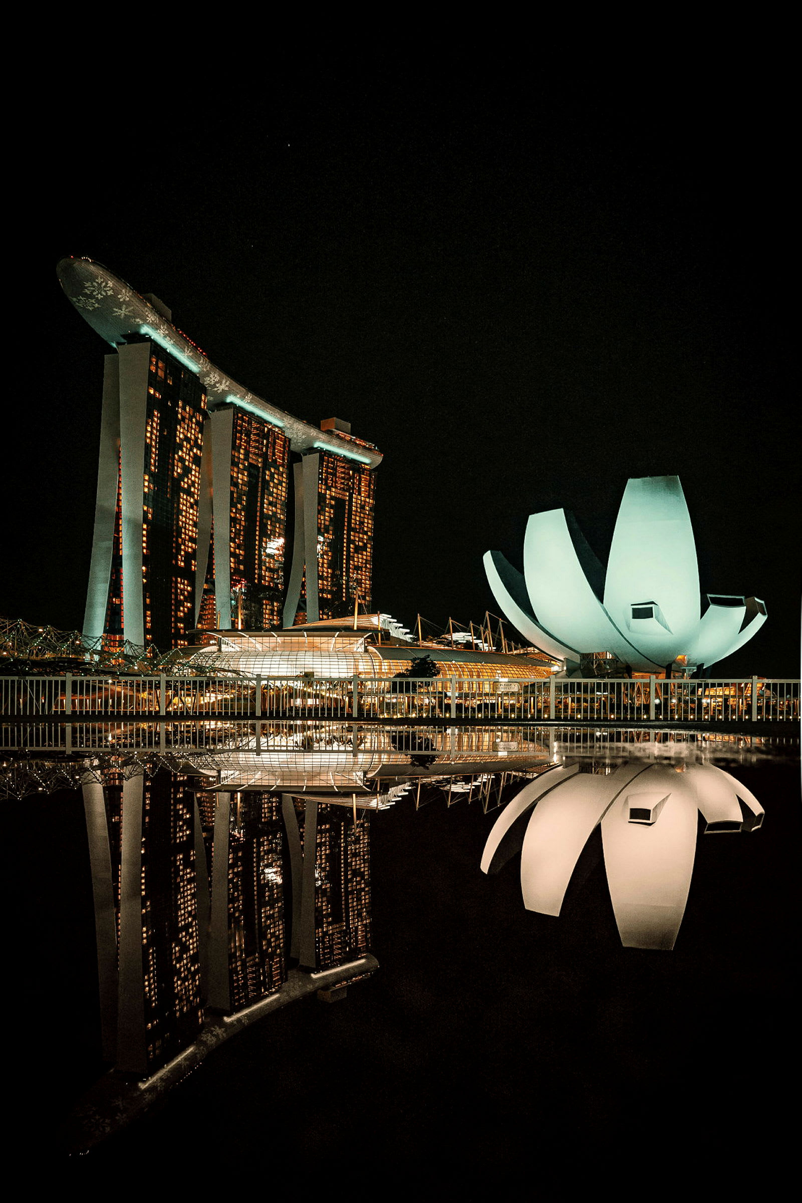 Marina Bay Sands ja ArtScience Museum heijastuvat veteen öiseen aikaan Singaporessa. (Tekoälyn luoma teksti)