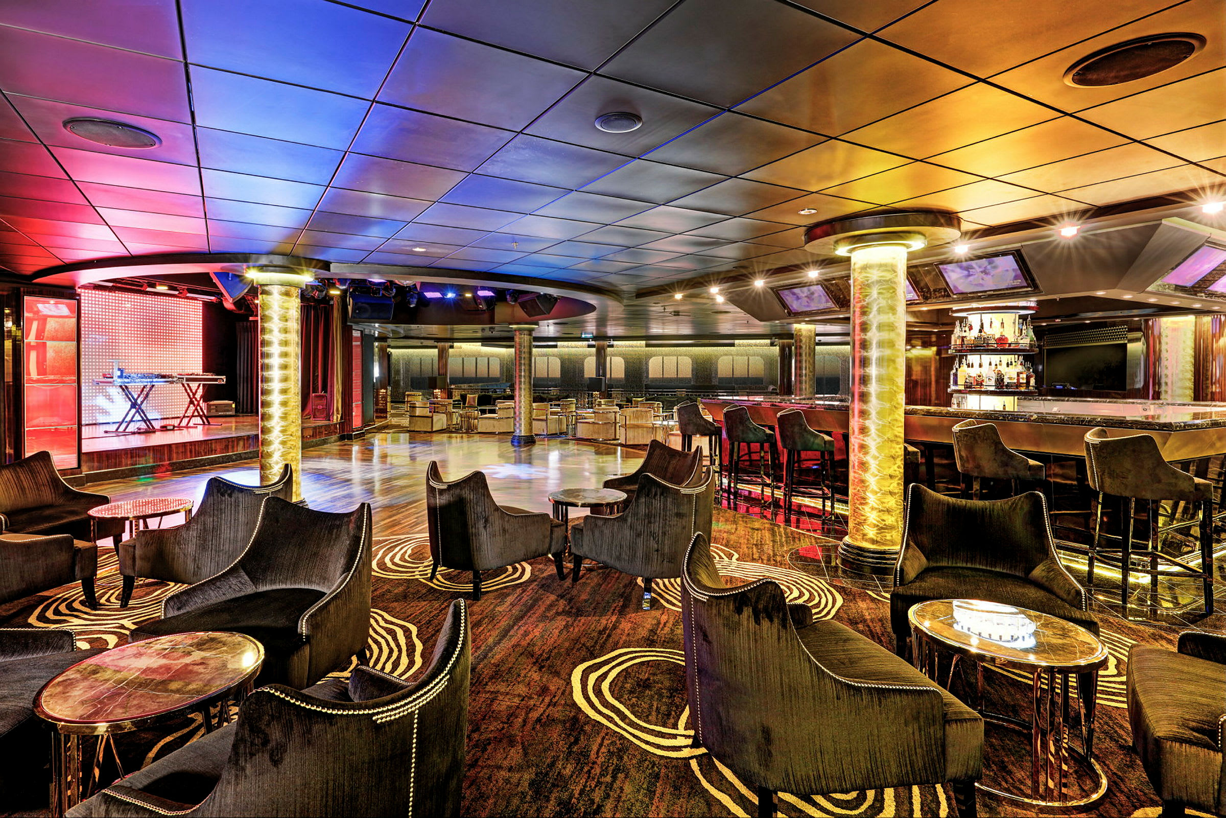 Moderni lounge, jossa baari ja istumapaikkoja värikkäässä ja tyylikkäässä ympäristössä. (Tekoälyn luoma teksti)
