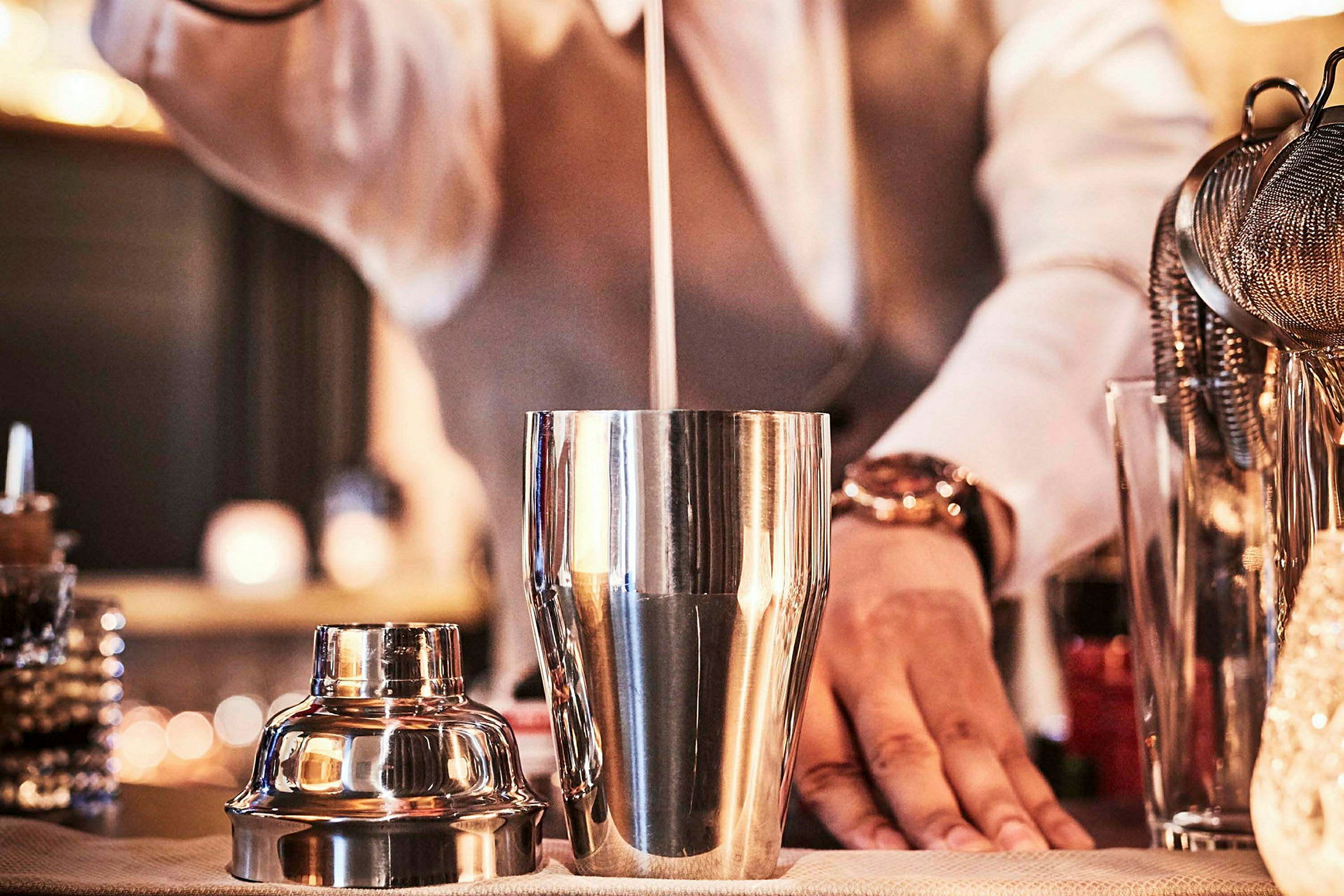 Baarimikko ravistaa cocktailia metallisessa shakerissa. (Tekoälyn luoma teksti)