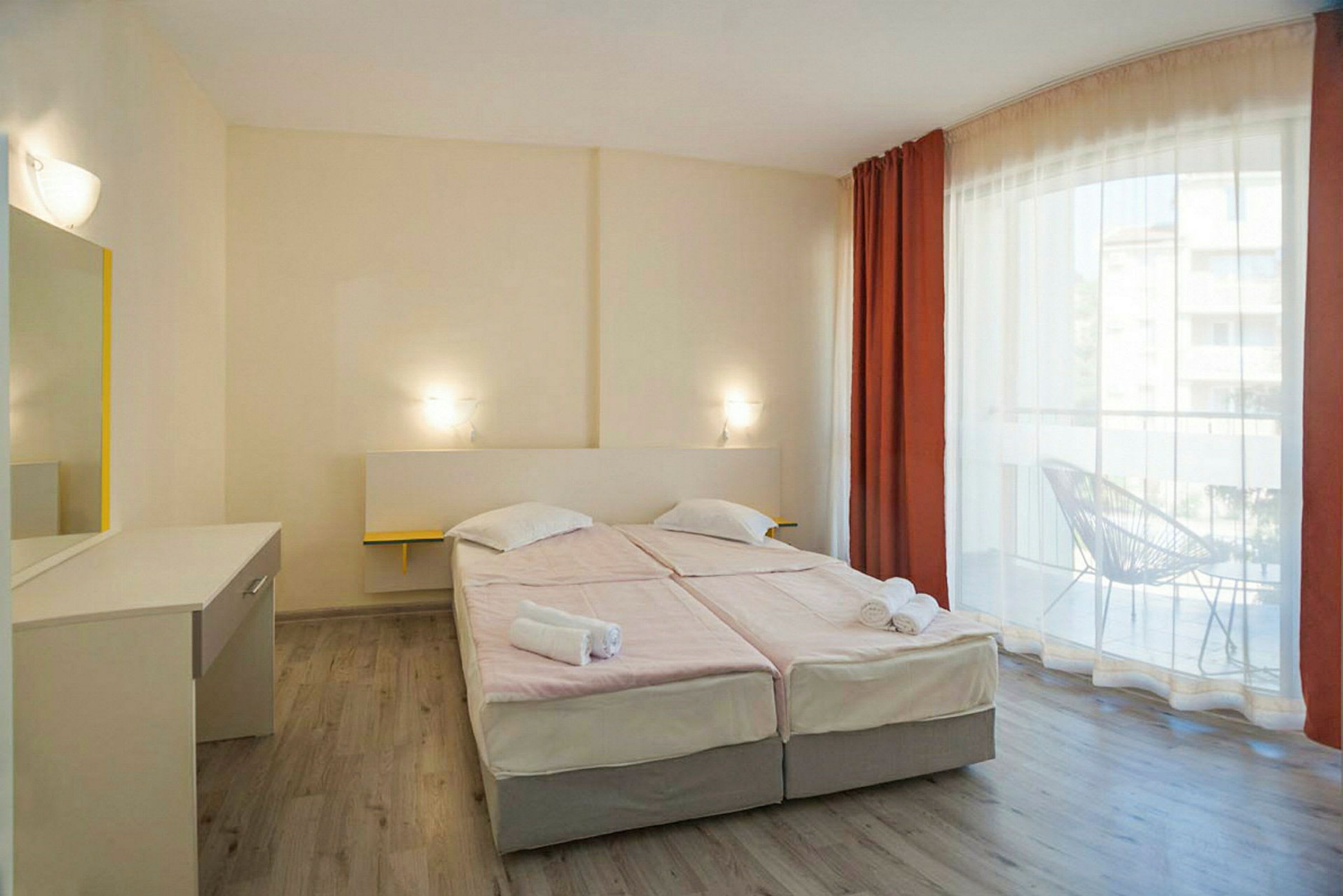 Hotellihuone, jossa kaksi vuodetta ja parveke. (Tekoälyn luoma teksti)