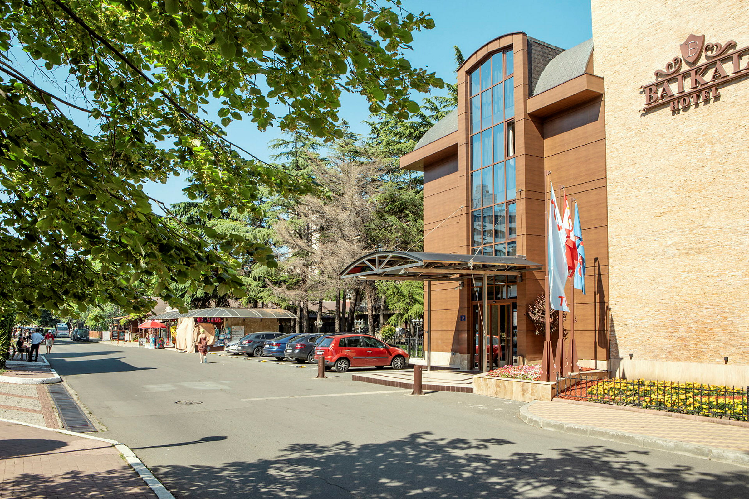 Hotel Baikalin etupuoli, jossa on pysäköintialue ja lippuja sisäänkäynnin luona. (Tekoälyn luoma teksti)