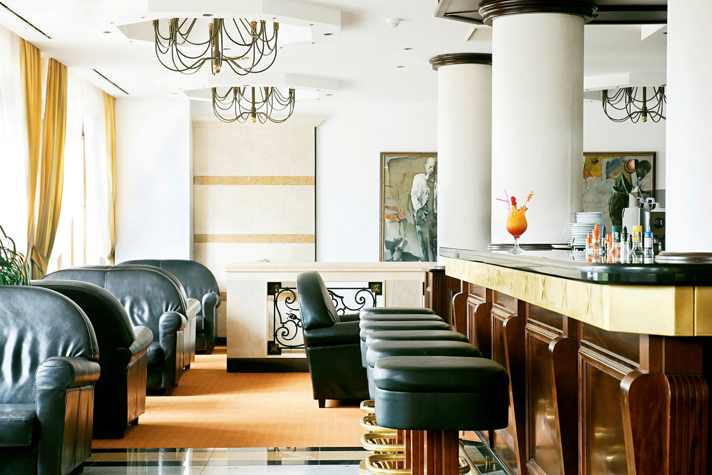 Elegantti hotellihuone, jossa on tuoleja ja baarituoleja baaritiskin edessä. (Tekoälyn luoma teksti)