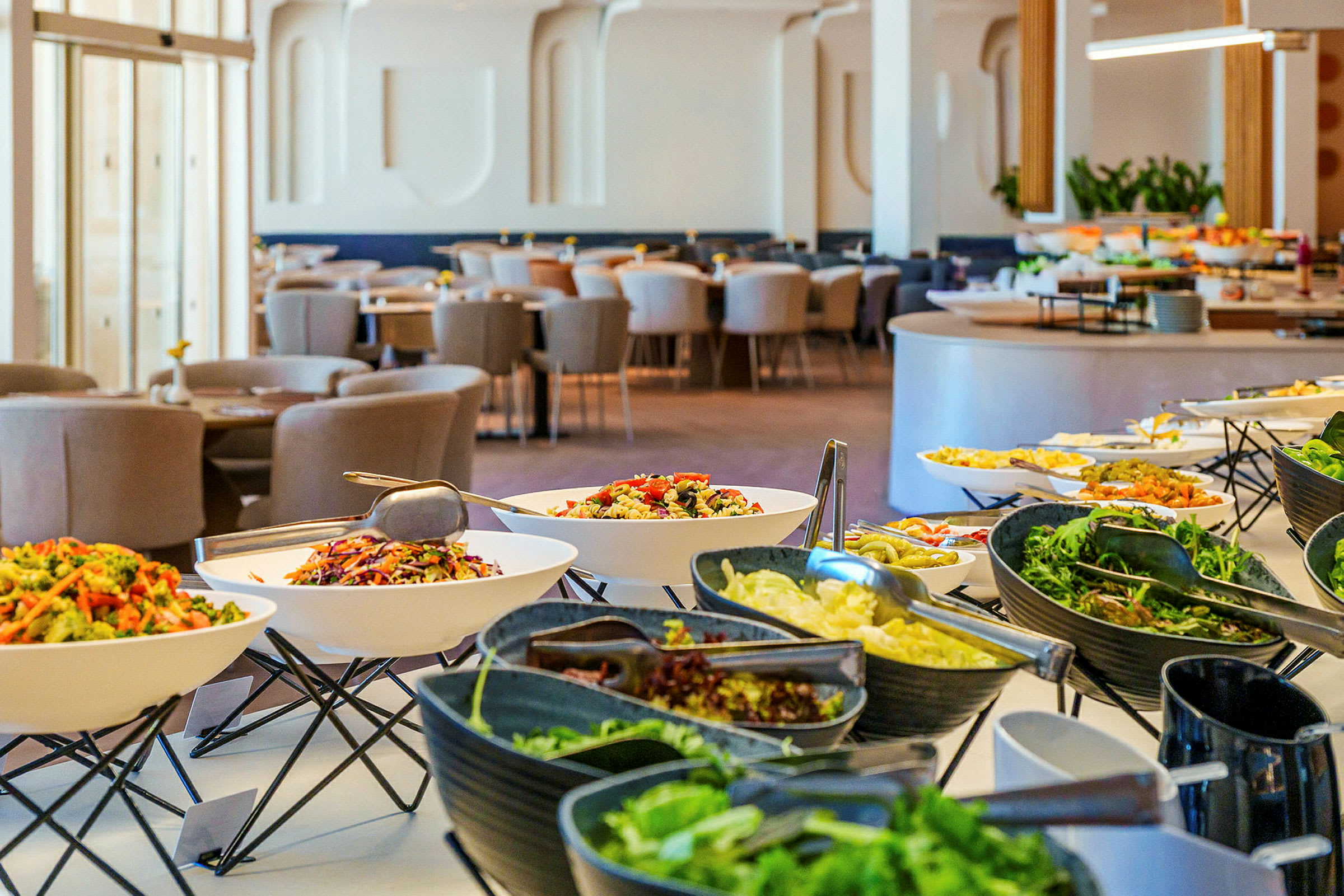 Buffet, jossa on erilaisia salaatteja ja ruokia, valoisassa ja modernissa ravintolassa. (Tekoälyn luoma teksti)