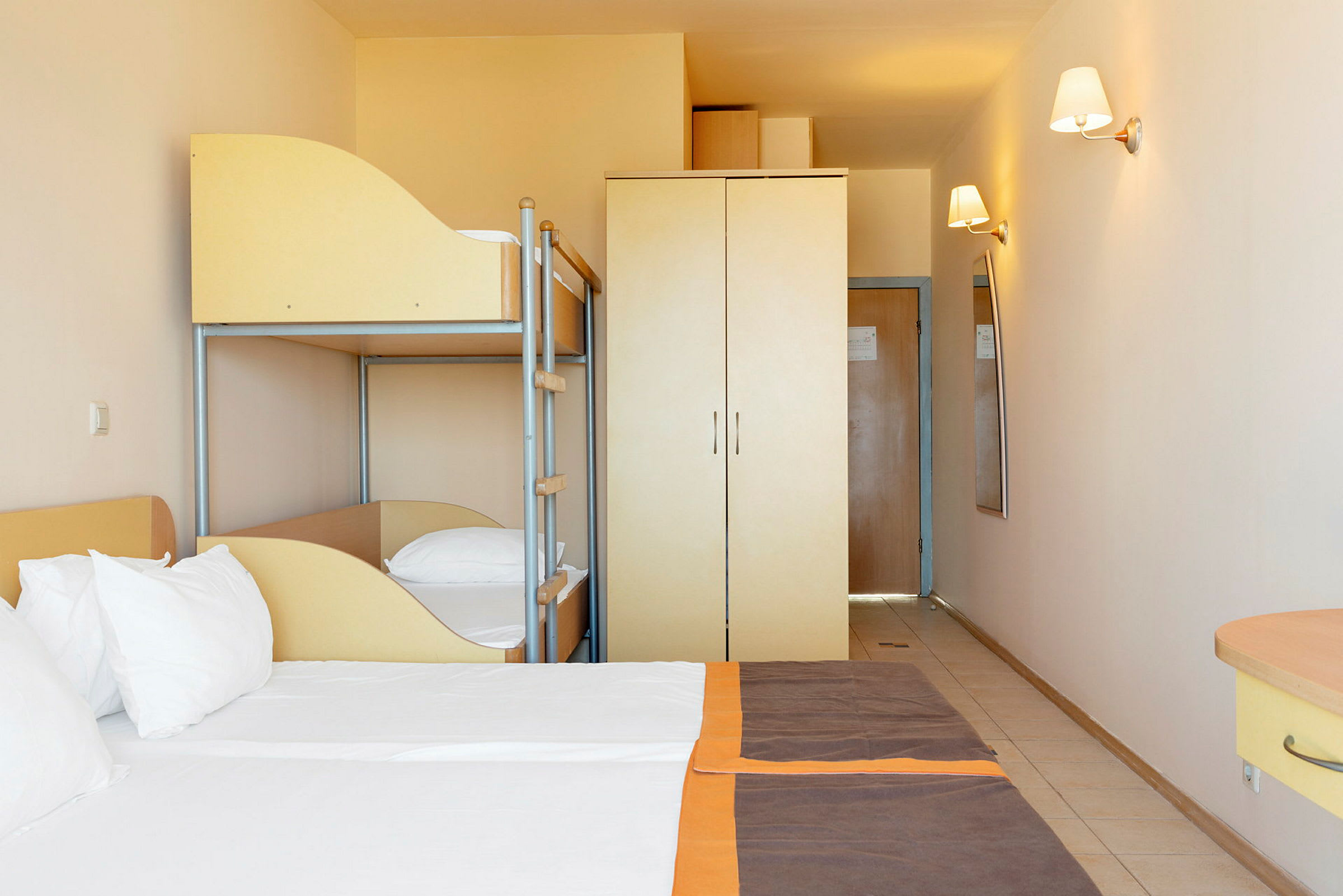 Hotellihuone, jossa on parivuode, kerrossänky ja vaatekaappi. (Tekoälyn luoma teksti)