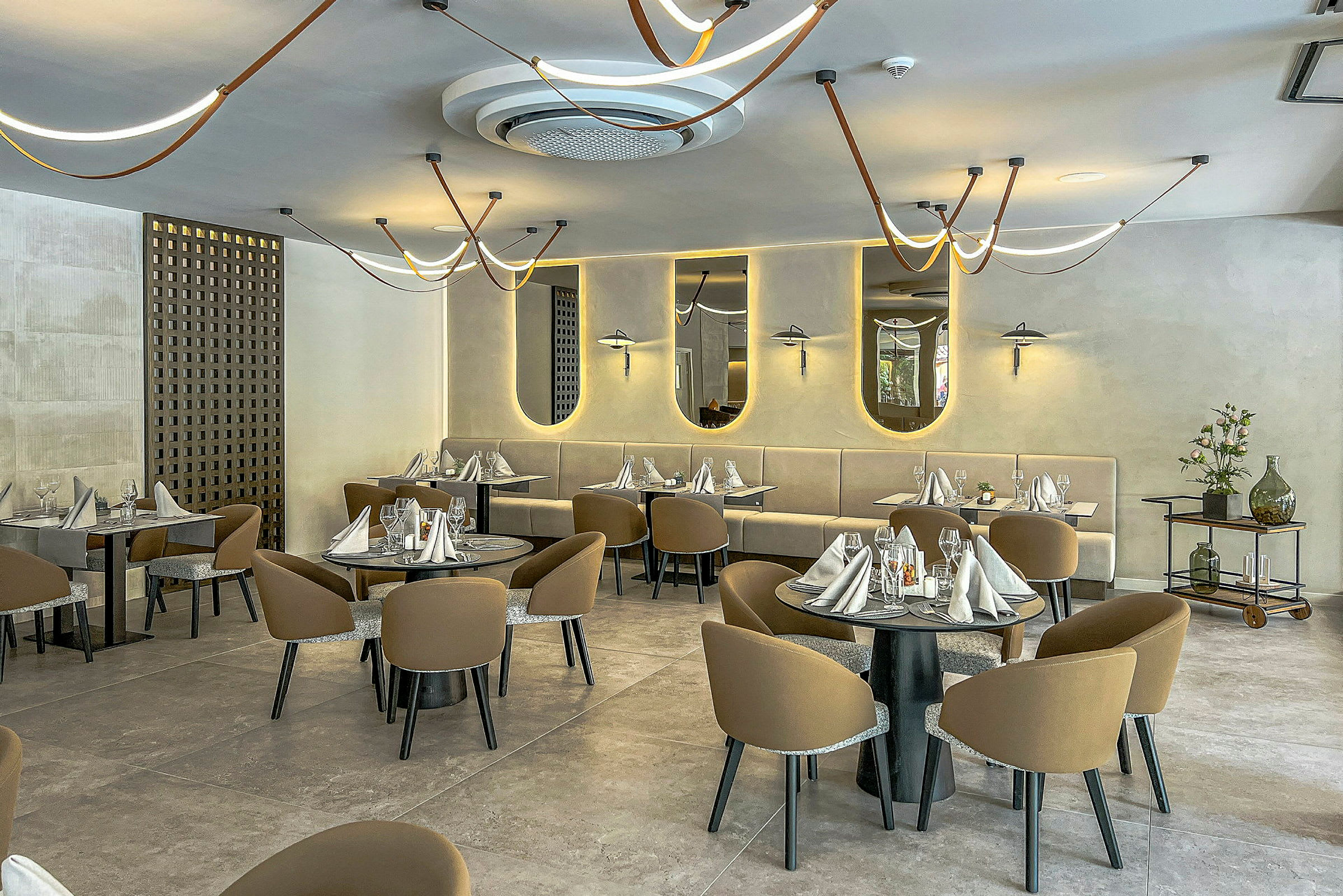 Tyylikäs ravintola, jossa on katettuja pöytiä ja moderneja valaisimia. (Tekoälyn luoma teksti)