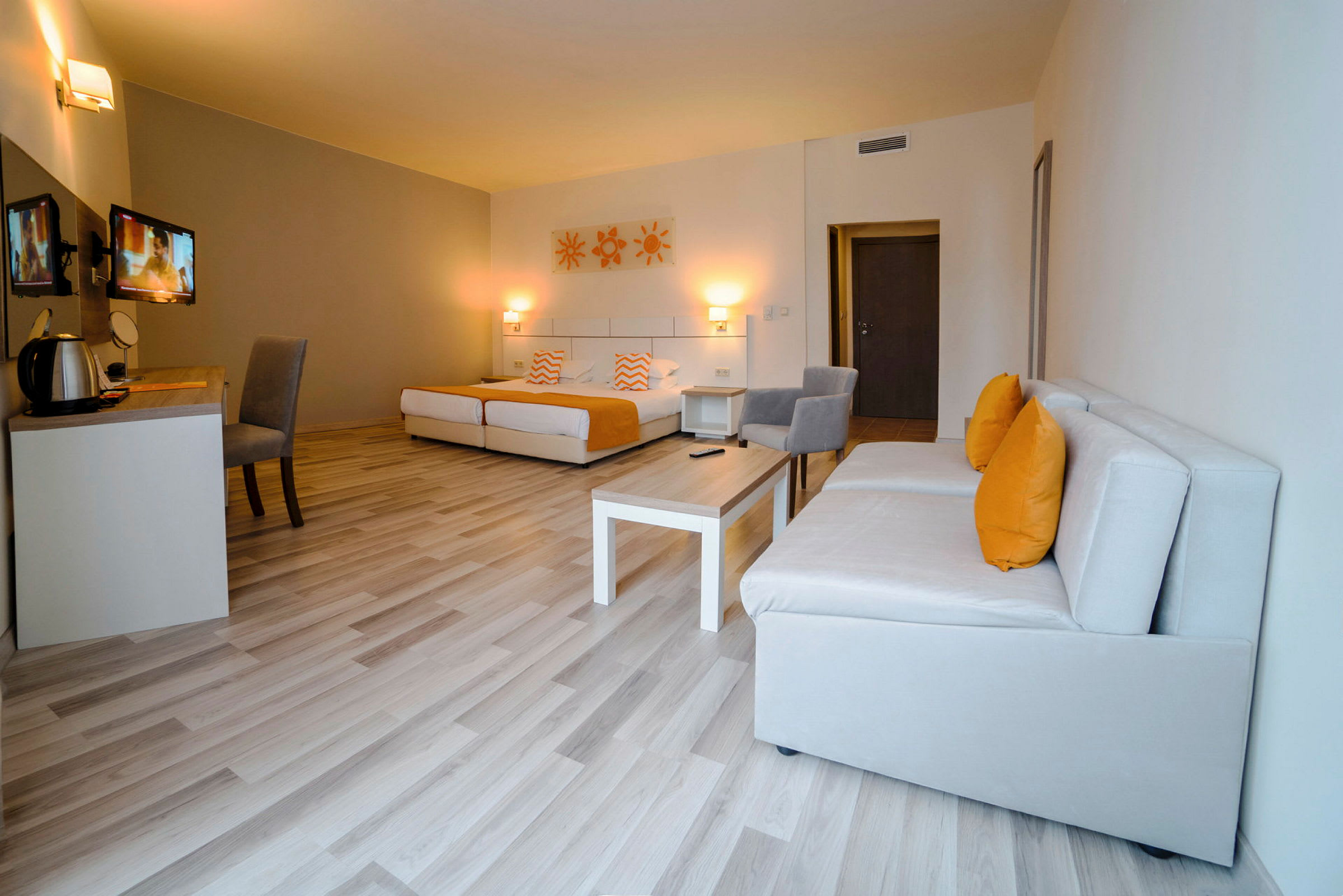 Moderni hotellihuone, jossa sängyt, sohvat ja työpöytä. (Tekoälyn luoma teksti)