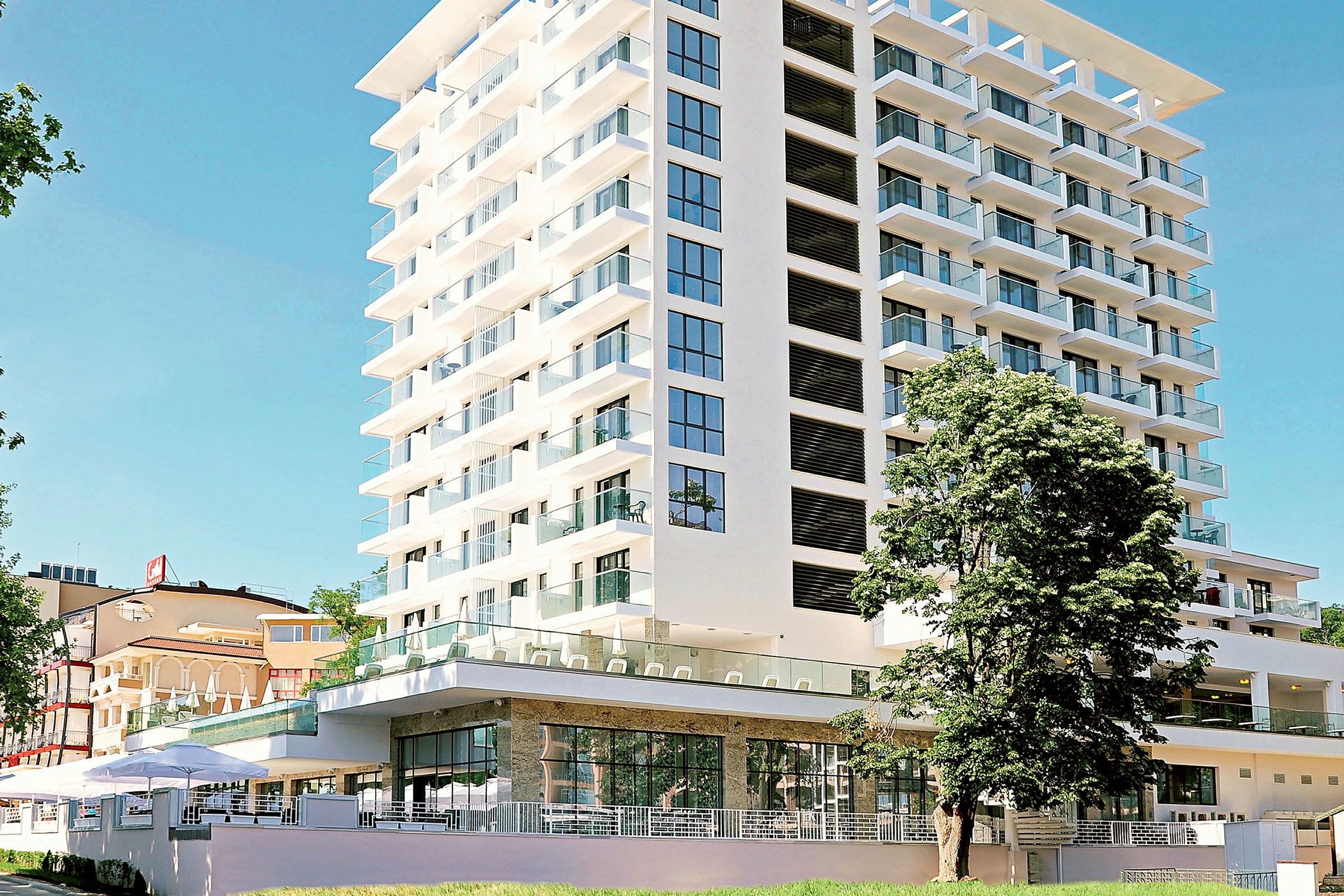 Moderni hotellirakennus, jossa lasiparvekkeet ja suuret ikkunat. (Tekoälyn luoma teksti)