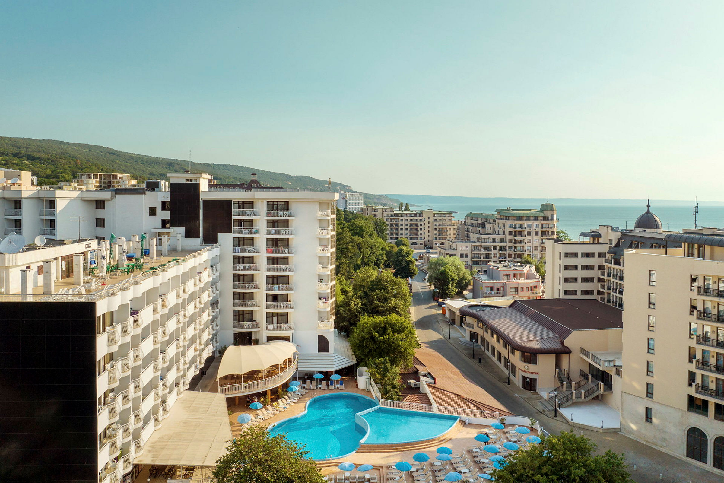 Hotellirakennuksia, etualalla uima-allas ja taustalla meri. (Tekoälyn luoma teksti)