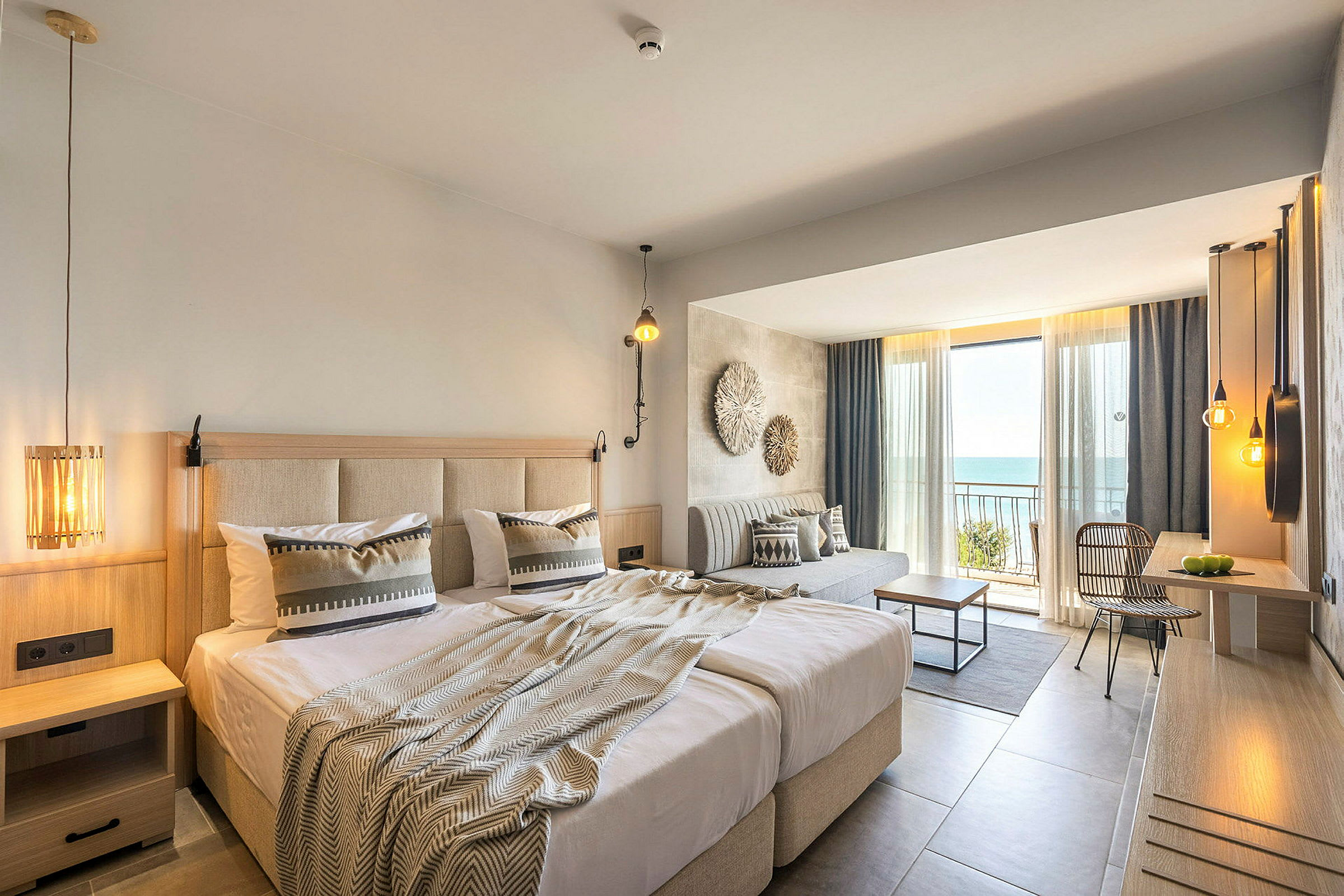 Hotellihuone, jossa parivuode, istuma-alue ja parveke merinäköalalla. (Tekoälyn luoma teksti)